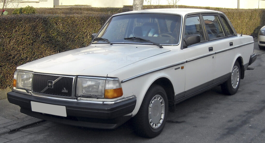Volvo 240 kombi w kolorze białym zaparkowane przy chodniku