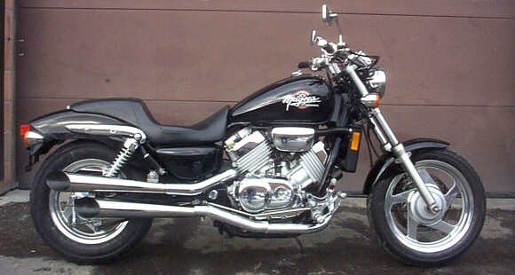 „Honda Magna VF750C z 1999 roku – widok z boku, klasyczny cruiser z silnikiem V4, czarny lakier, chromowane wydechy, nisko osadzone siedzisko.