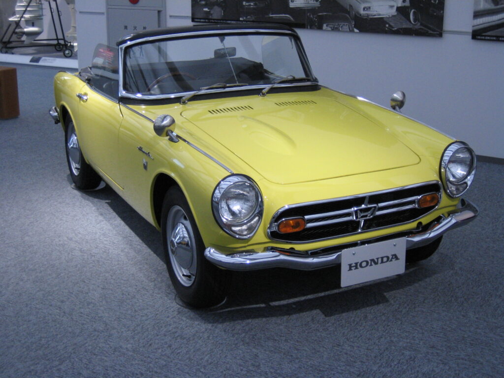 Żółta Honda S800 roadster z lat 60. – klasyczny japoński samochód sportowy JDM o wysokich obrotach, wystawiony w muzeum Hondy