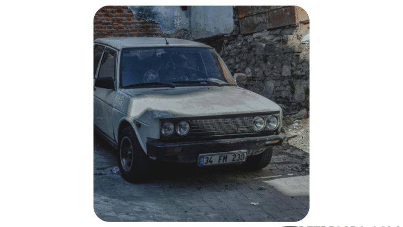 Zardzewiały Fiat 131 zaparkowany przy zrujnowanym murze, z wyraźnymi śladami zużycia i zniszczeń. U góry napis „Złom to nie youngtimer!”, w prawym dolnym rogu logo retricars.com z podpisem „Giełda Motoryzacji Klasycznej”.