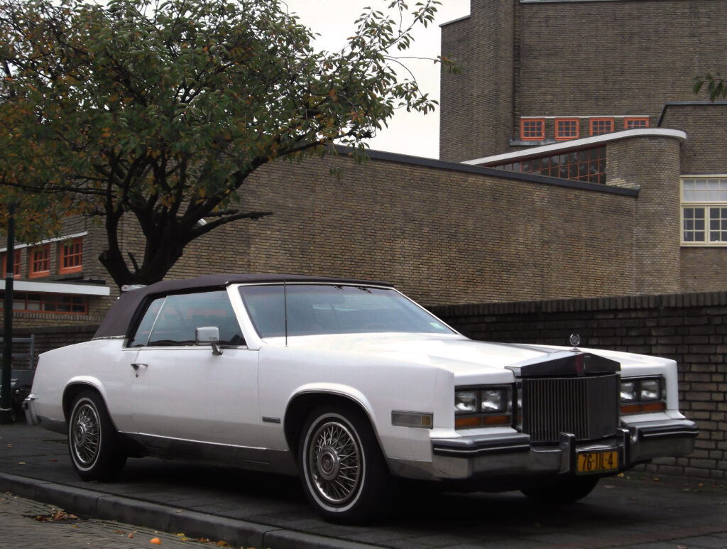 Cadillac Eldorado Convertible z początku lat 80. – reprezentant dziesiątej generacji, łączącej klasyczny styl z nowoczesną elektroniką i eksperymentalnym silnikiem V8-6-4. Zdjęcie: Autorstwa Dennis Elzinga - Cadillac Eldorado, CC BY 2.0, https://commons.wikimedia.org/w/index.php?curid=38638878