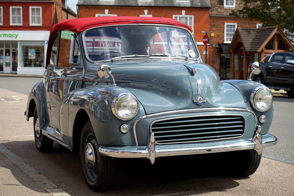 Klasyczny Morris Minor z czerwonym dachem zaparkowany na ulicy w miasteczku