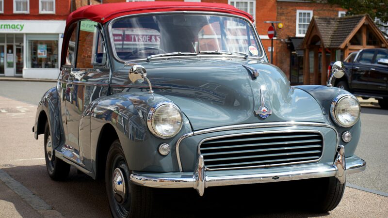 Klasyczny Morris Minor z czerwonym dachem zaparkowany na ulicy w miasteczku